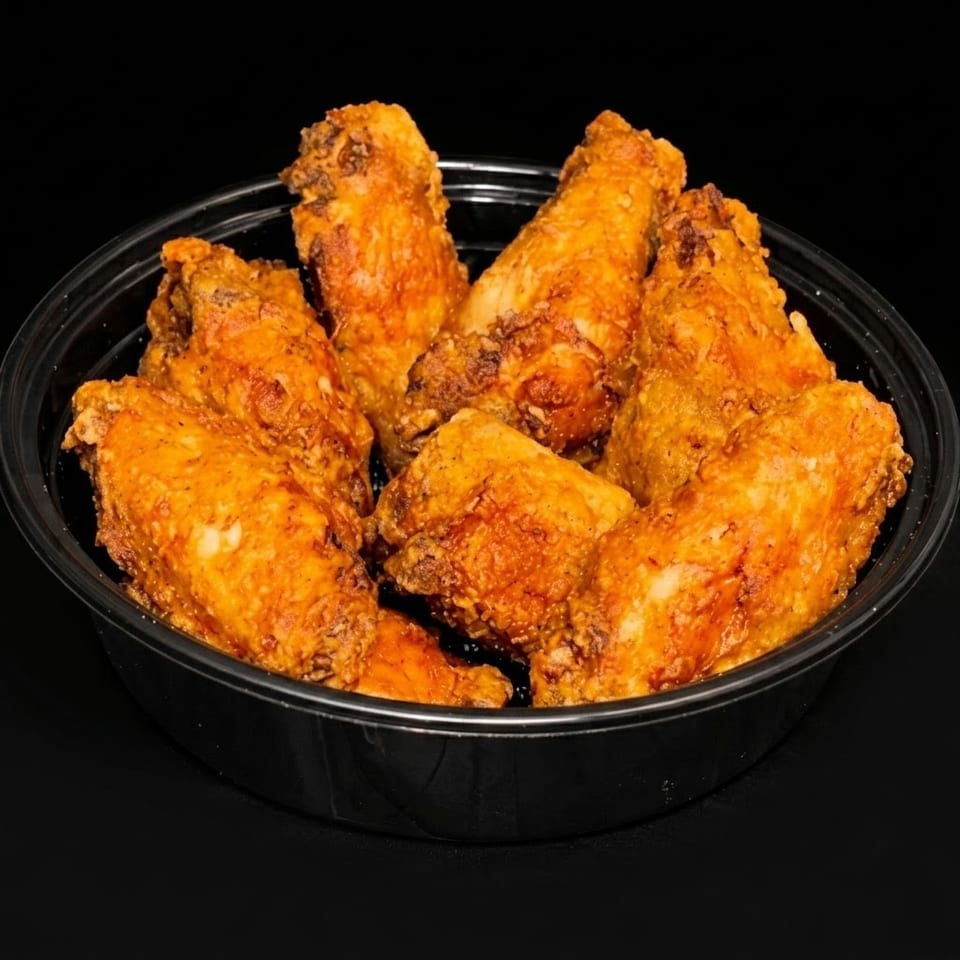 Crispy, golden-brown fried chicken wings served in a black takeout bowl.